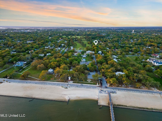 aerial view at dusk featuring a water view