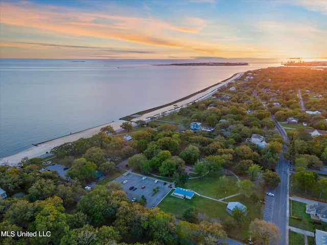 aerial view at dusk featuring a water view