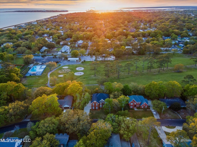 aerial view at dusk featuring a water view