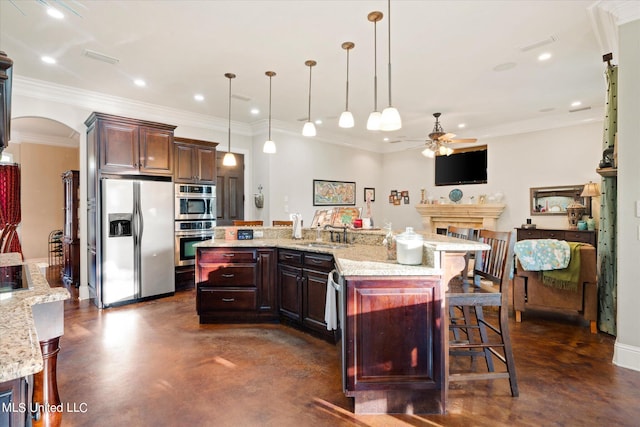 kitchen with a breakfast bar area, a kitchen island with sink, pendant lighting, crown molding, and stainless steel appliances