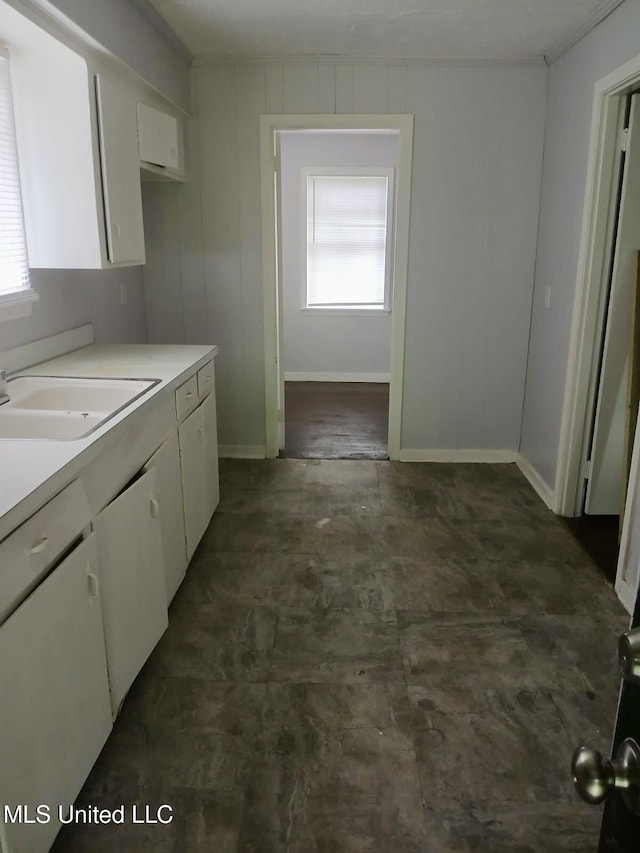 kitchen featuring plenty of natural light, white cabinetry, light countertops, and a sink