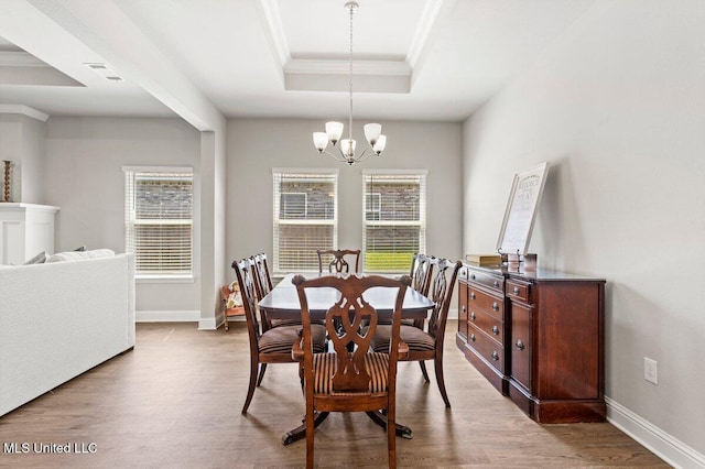 15380 Woodmanse Way, Diberville, MS 39540 - dining area with crown molding, a tray ceiling, a chandelier, wood finished floors, and baseboards
