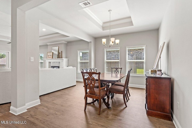 15380 Woodmanse Way, Diberville, MS 39540 - dining area featuring ornamental molding, a raised ceiling, wood finished floors, healthy amount of natural light, and a chandelier