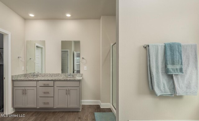 15380 Woodmanse Way, Diberville, MS 39540 - full bath featuring wood finished floors, a shower stall, double vanity, baseboards, and recessed lighting
