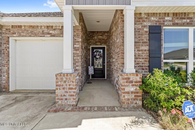 15380 Woodmanse Way, Diberville, MS 39540 - view of exterior entry featuring brick siding, a garage, and a porch