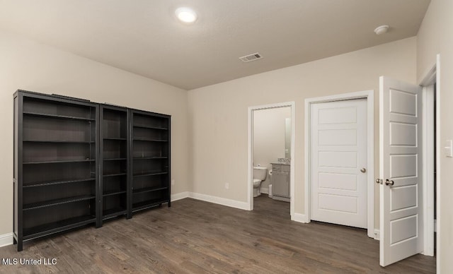 15380 Woodmanse Way, Diberville, MS 39540 - unfurnished bedroom with dark wood-type flooring, baseboards, and ensuite bathroom