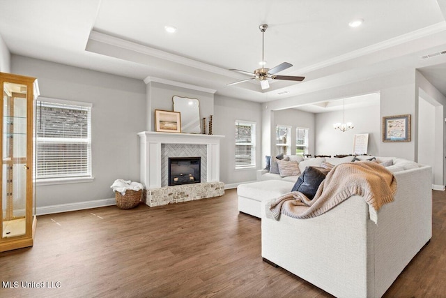 15380 Woodmanse Way, Diberville, MS 39540 - living area featuring a raised ceiling, crown molding, a ceiling fan, baseboards, and dark wood finished floors