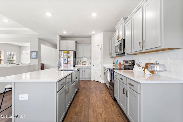 15380 Woodmanse Way, Diberville, MS 39540 - kitchen featuring appliances with stainless steel finishes, gray cabinets, backsplash, recessed lighting, and a breakfast bar