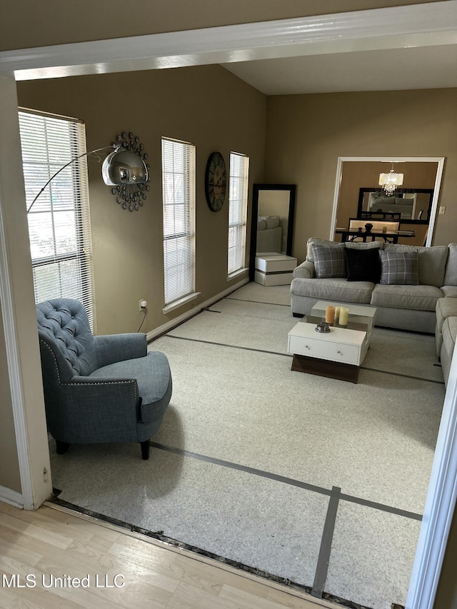 living room featuring lofted ceiling, plenty of natural light, and a notable chandelier