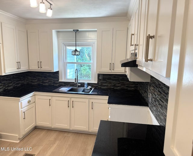 1708 Robinson St, Natchez, MS 39120 - kitchen with dark countertops, light wood-style floors, white cabinetry, and a sink