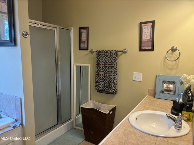 bathroom with a shower with door, vanity, and tile patterned floors