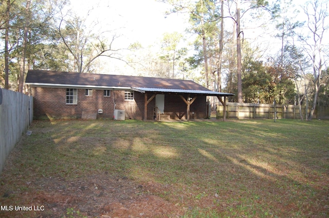 back of property featuring brick siding, crawl space, a lawn, and a fenced backyard