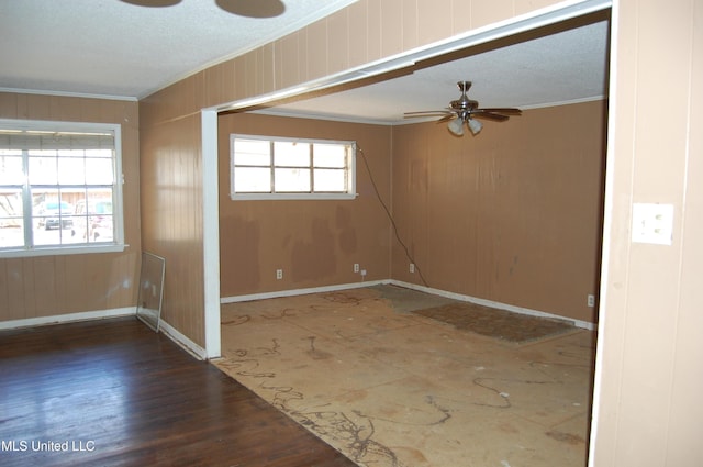 empty room featuring a wealth of natural light, ceiling fan, and crown molding