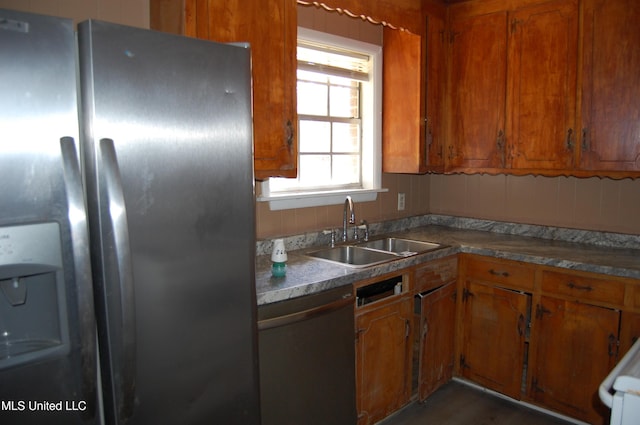 kitchen featuring a sink, refrigerator with ice dispenser, brown cabinetry, and dishwasher