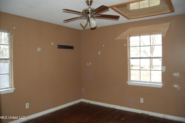 empty room with baseboards, dark wood finished floors, and a ceiling fan