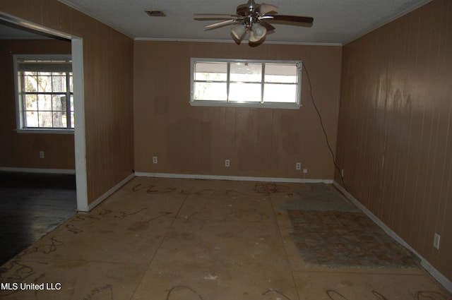 spare room with crown molding, plenty of natural light, baseboards, and visible vents