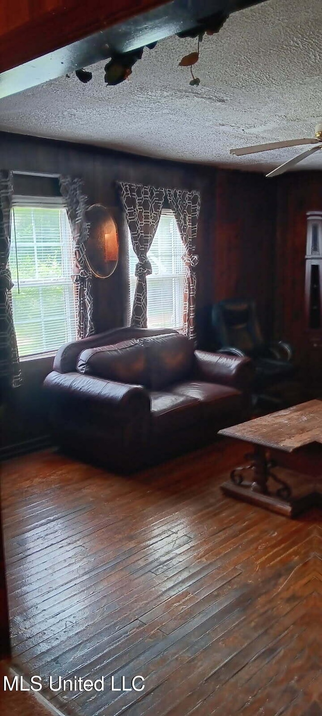 living area featuring wood-type flooring and a textured ceiling