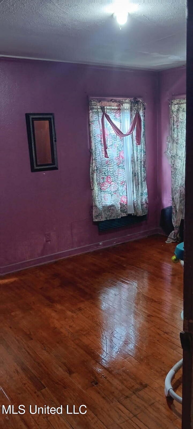 spare room featuring a textured ceiling and hardwood / wood-style flooring