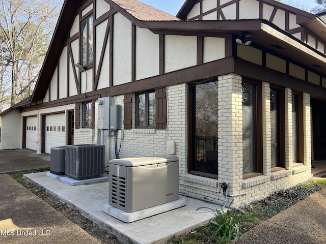 1609 SW Linda Dr, Clinton, MS 39056 - view of home's exterior featuring brick siding, a garage, central AC unit, and a shingled roof