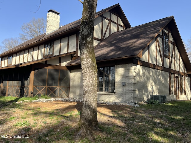 1609 SW Linda Dr, Clinton, MS 39056 - back of property featuring brick siding, a chimney, central air condition unit, and roof with shingles