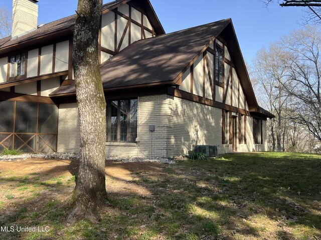 1609 SW Linda Dr, Clinton, MS 39056 - view of side of property with brick siding, a chimney, a yard, central air condition unit, and roof with shingles
