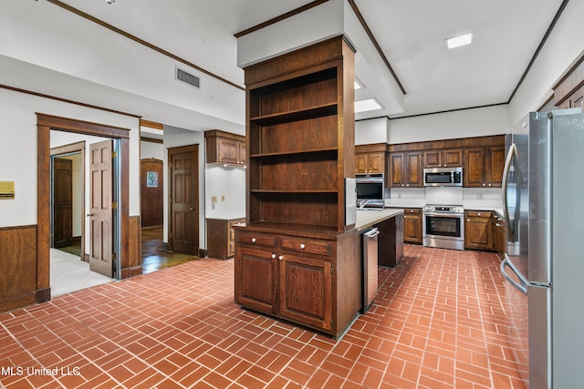 kitchen featuring appliances with stainless steel finishes, dark brown cabinets, and wood walls