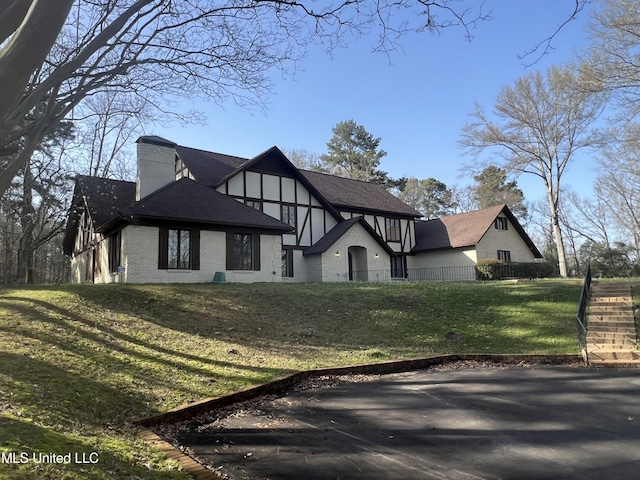 1609 SW Linda Dr, Clinton, MS 39056 - tudor house featuring a chimney and brick siding