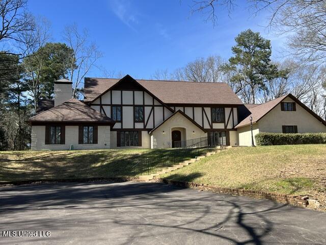 1609 SW Linda Dr, Clinton, MS 39056 - tudor house with a chimney, stucco siding, and a front lawn
