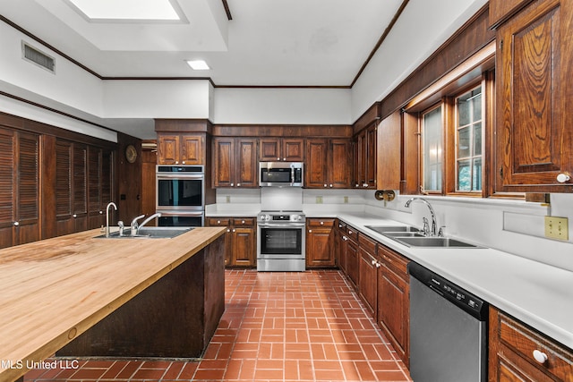 kitchen with wooden counters, stainless steel appliances, and sink