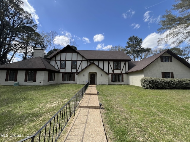 1609 SW Linda Dr, Clinton, MS 39056 - tudor-style house featuring brick siding, a chimney, and roof with shingles