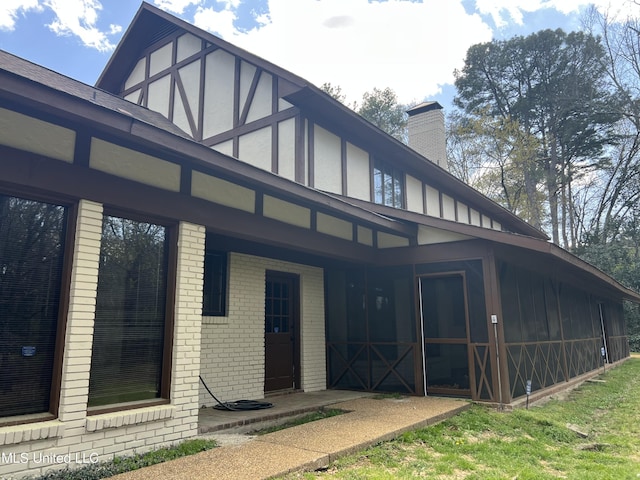 1609 SW Linda Dr, Clinton, MS 39056 - back of house featuring brick siding, a chimney, and a sunroom