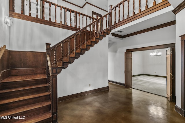 1609 SW Linda Dr, Clinton, MS 39056 - stairs featuring finished concrete flooring, a chandelier, baseboards, ornamental molding, and a high ceiling