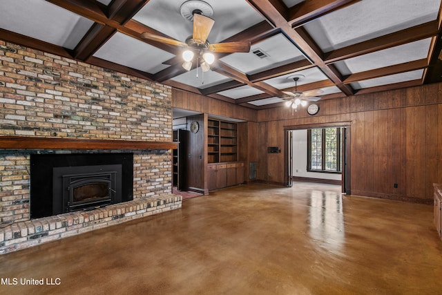 unfurnished living room featuring wood walls, coffered ceiling, beam ceiling, a brick fireplace, and ceiling fan