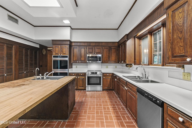 1609 SW Linda Dr, Clinton, MS 39056 - kitchen with stainless steel appliances, brick patterned floors, butcher block counters, and a sink