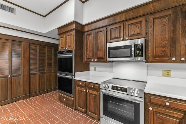 1609 SW Linda Dr, Clinton, MS 39056 - kitchen featuring stainless steel appliances, brick patterned floors, light countertops, crown molding, and dark brown cabinetry