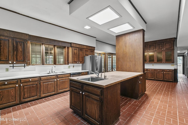 1609 SW Linda Dr, Clinton, MS 39056 - kitchen featuring a sink, brick floors, stainless steel appliances, and an island with sink