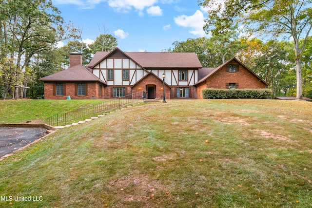 tudor-style house featuring a front yard