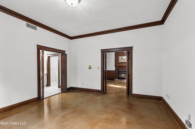 spare room with ornamental molding and a textured ceiling