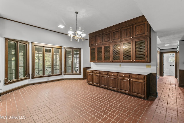 1609 SW Linda Dr, Clinton, MS 39056 - kitchen with brick patterned flooring, a chandelier, light countertops, and dark brown cabinets