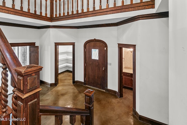 entryway featuring plenty of natural light, crown molding, and a high ceiling