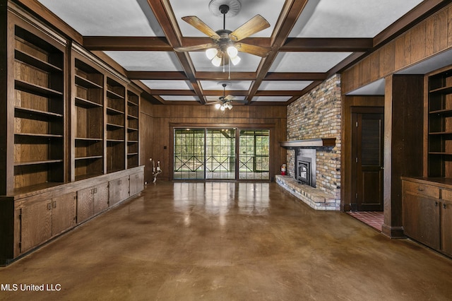 1609 SW Linda Dr, Clinton, MS 39056 - unfurnished living room featuring ceiling fan, wooden walls, concrete floors, a fireplace, and beamed ceiling