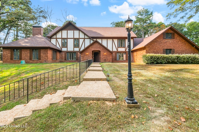 english style home with a front yard