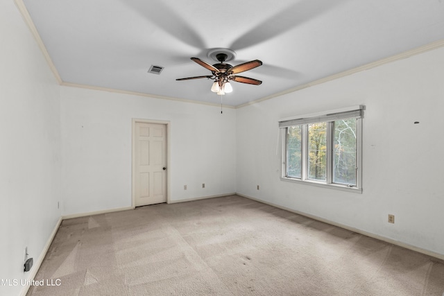 spare room featuring ornamental molding, light colored carpet, and ceiling fan