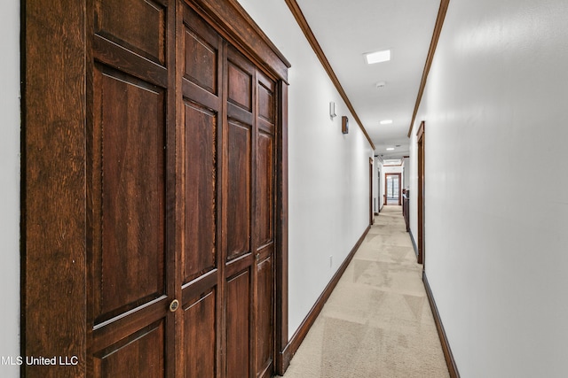 hallway with ornamental molding and light carpet