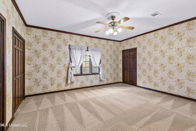 spare room featuring crown molding, light colored carpet, and ceiling fan