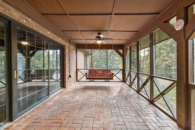 unfurnished sunroom with ceiling fan