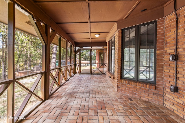 unfurnished sunroom featuring a healthy amount of sunlight and wooden ceiling