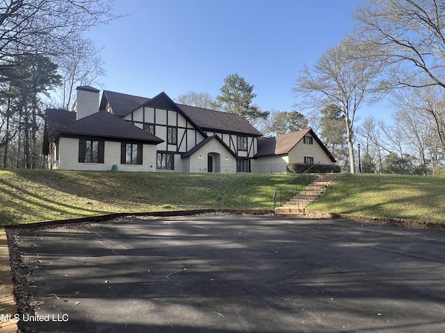 1609 SW Linda Dr, Clinton, MS 39056 - tudor house featuring a chimney and a front yard