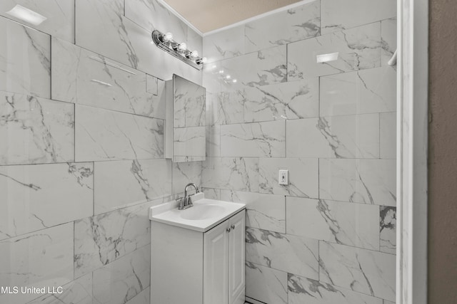 bathroom featuring vanity and tile walls