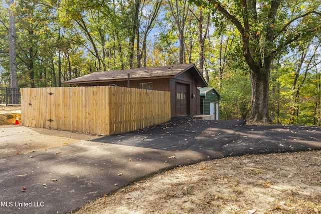 1609 SW Linda Dr, Clinton, MS 39056 - view of home's exterior featuring asphalt driveway, fence, and a carport